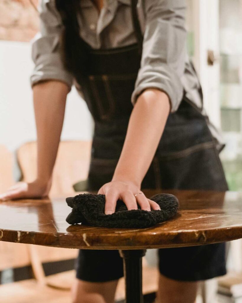 intentional homemaking photo of a woman wiping a table top