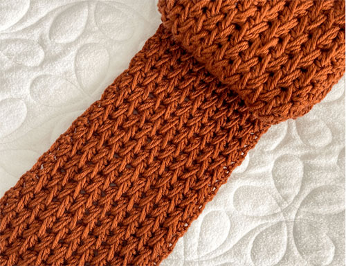 how to crochet the feather stitch photo of a scarf against a white background 