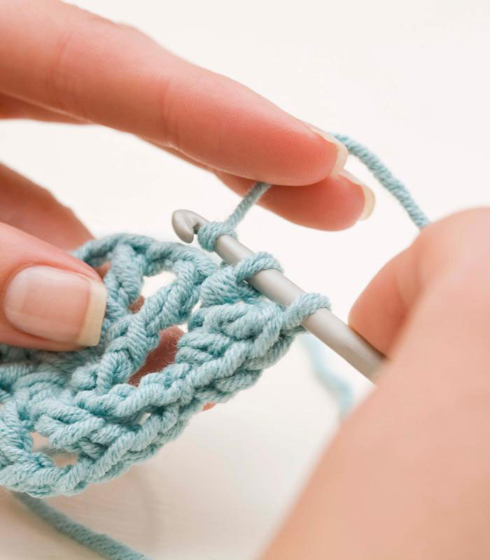 slow crochet making photo of a woman's hands crocheting 