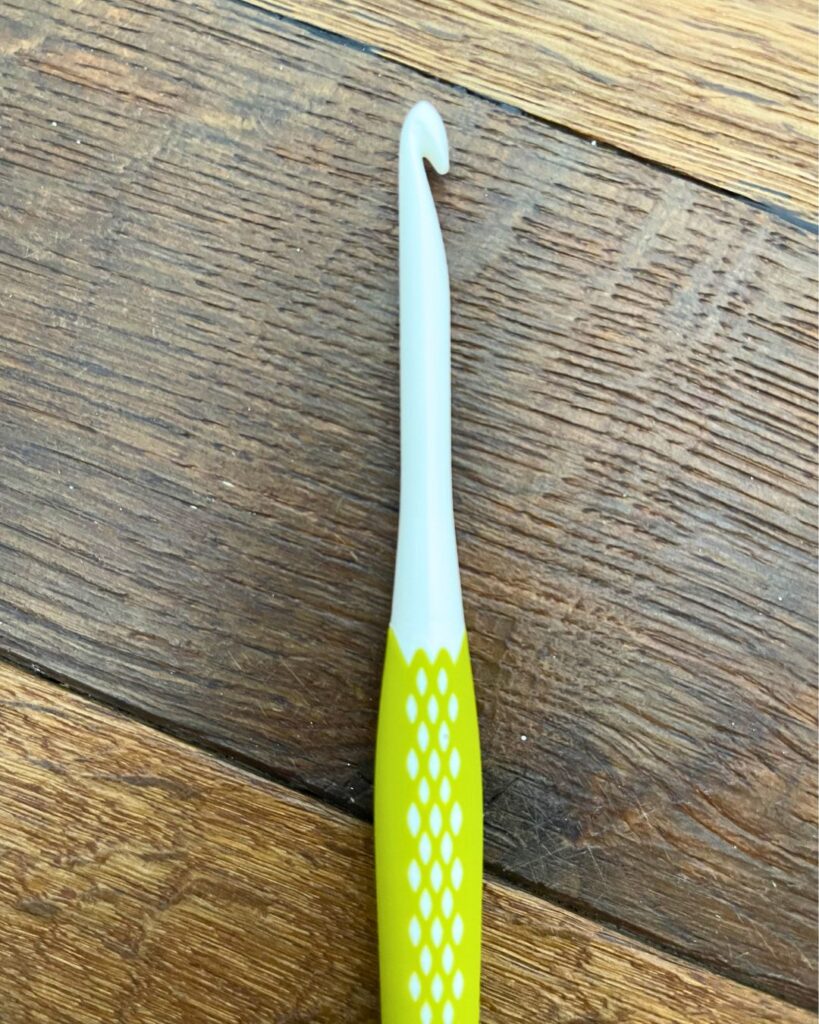 picture of a perm crochet hook on wood style background