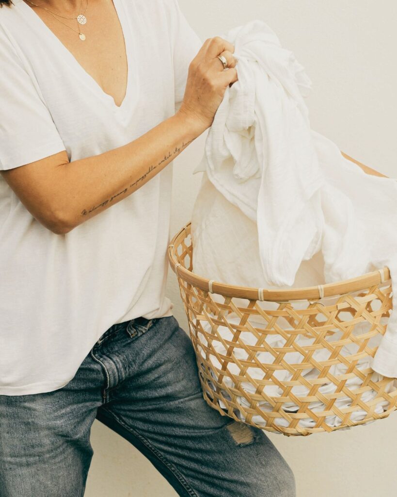 photo of woman holding an overflowing laundry basket serving your home with joy photo 