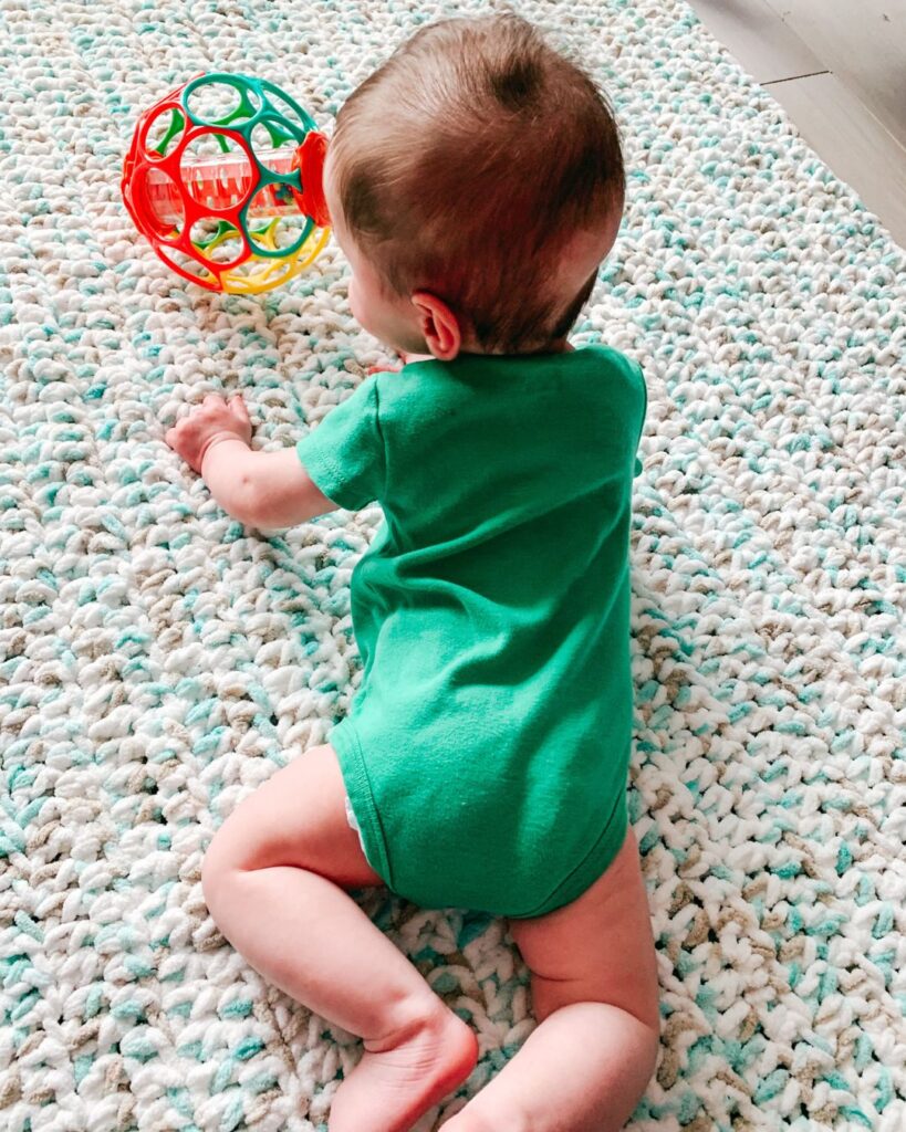 homemakers should crochet photo of a baby on a crochet blanket/play mat.