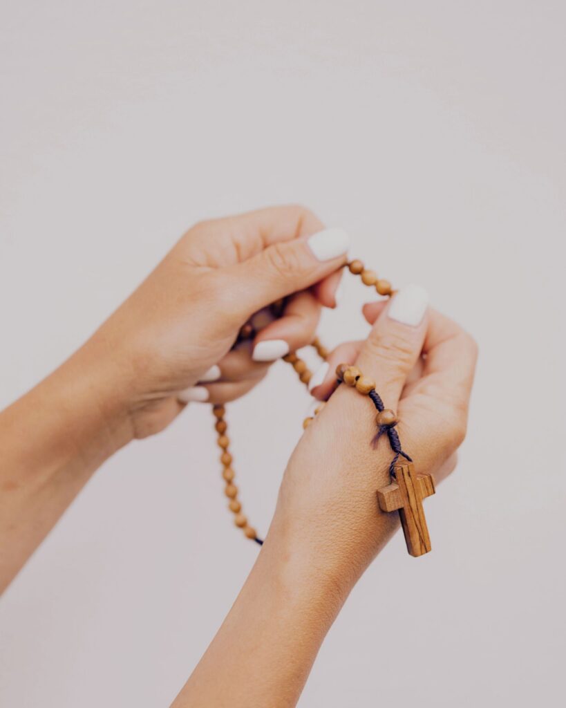 trusting in god's plan photo of a woman's hand holding a rosary 